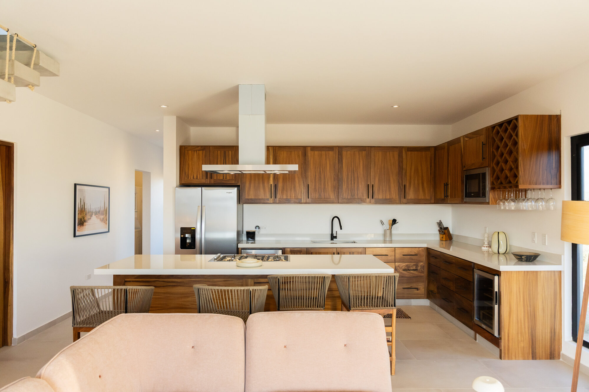 The kitchen with wooden cabinets and a long white island